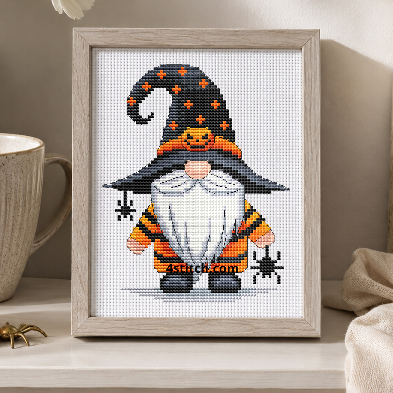 Spider Pumpkin Witch Gnome on white Aida in a small frame, photographed close up in a bright cozy autumn interior