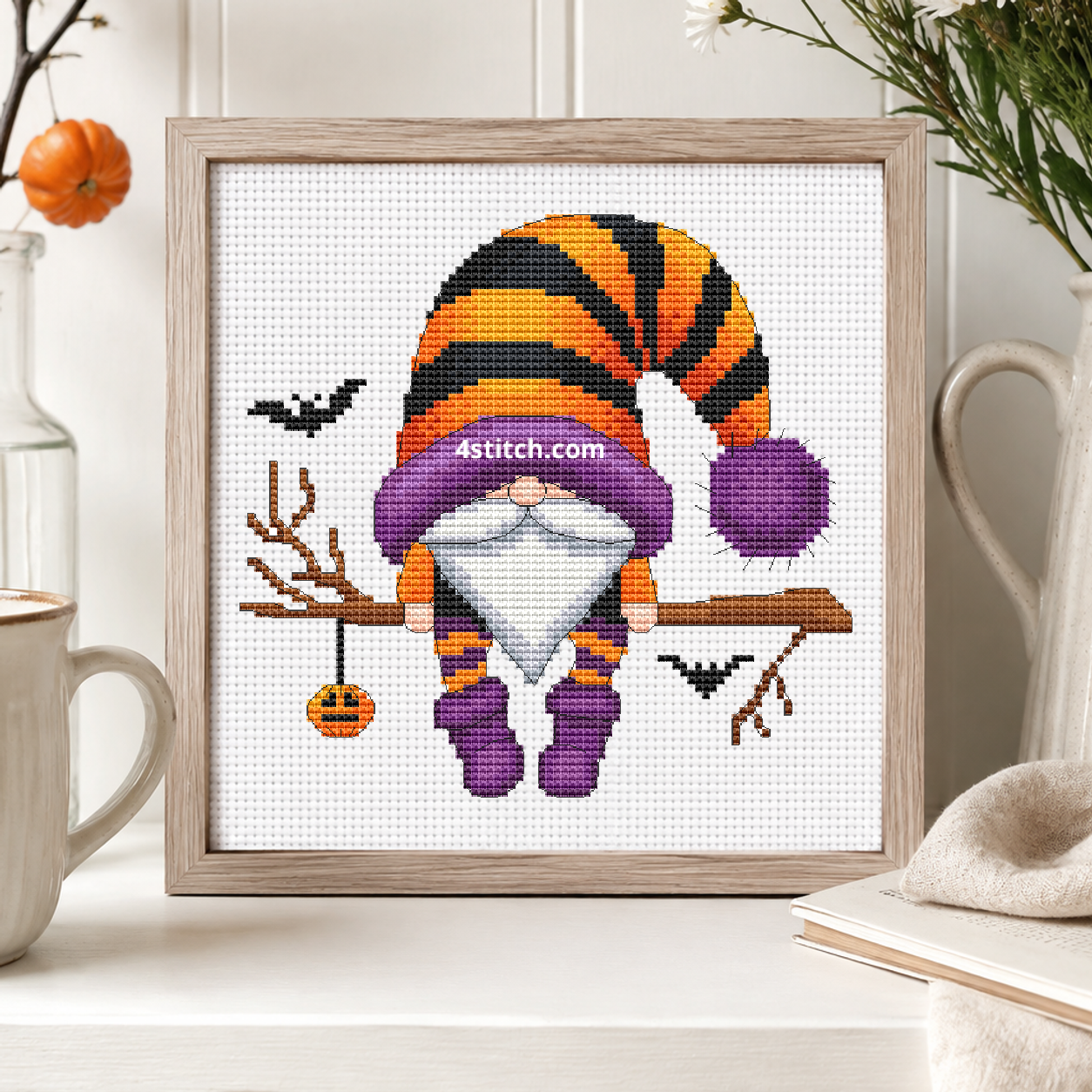 Pumpkin Charm Branch Halloween Gnome on white Aida in a small frame, photographed close up in a bright cozy autumn interior
