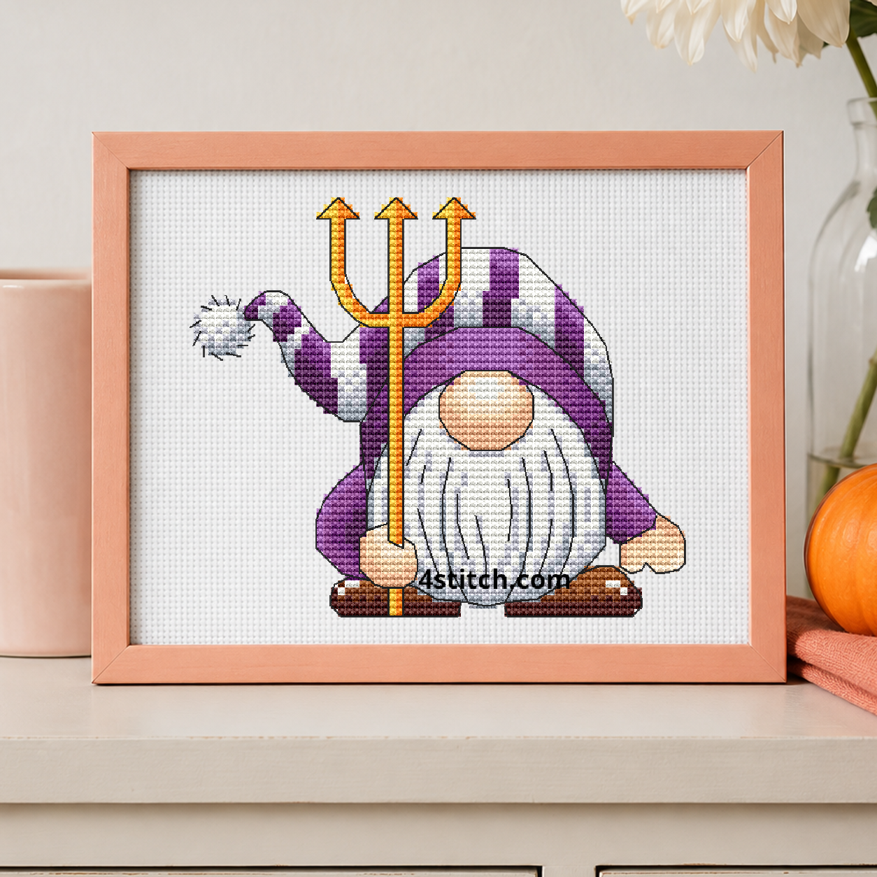 Devil Trident Halloween Gnome on white Aida in a small frame, photographed close up in a bright cozy autumn interior