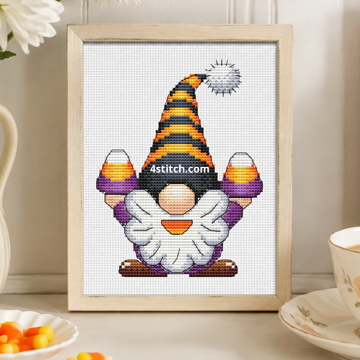 Candy Corn Halloween Gnome on white Aida in a small frame, photographed close up in a bright cozy autumn interior