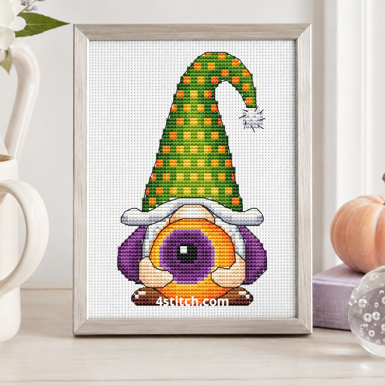 Eyeball Hat Halloween Gnome on white Aida in a small frame, photographed close up in a bright cozy autumn interior