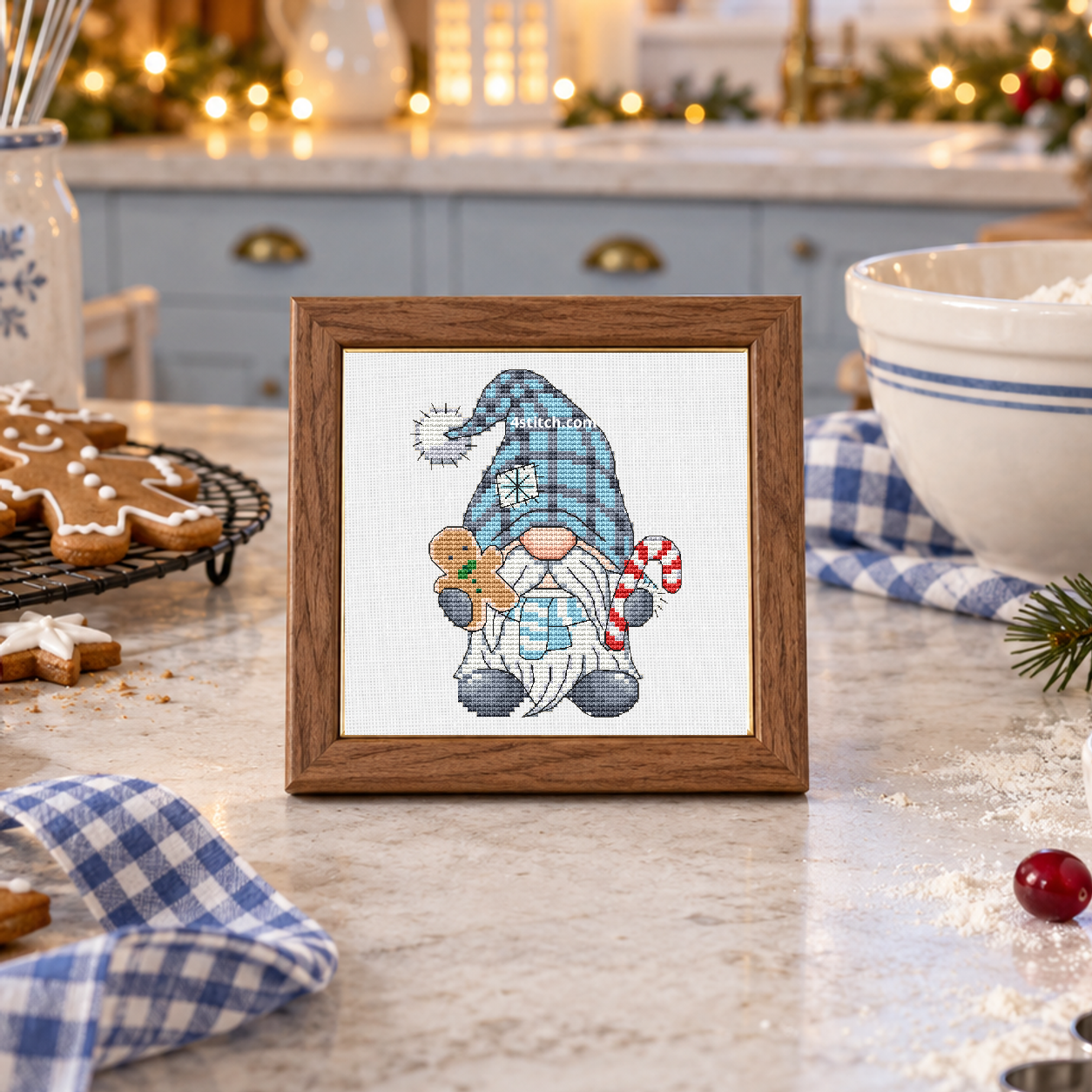 Gingerbread and Candy Cane Winter Gnome, featuring a blue-hatted gnome holding a gingerbread cookie and a candy cane, on white Aida in a small tabletop frame in a cheerful blue-and-ivory Christmas baking kitchen.