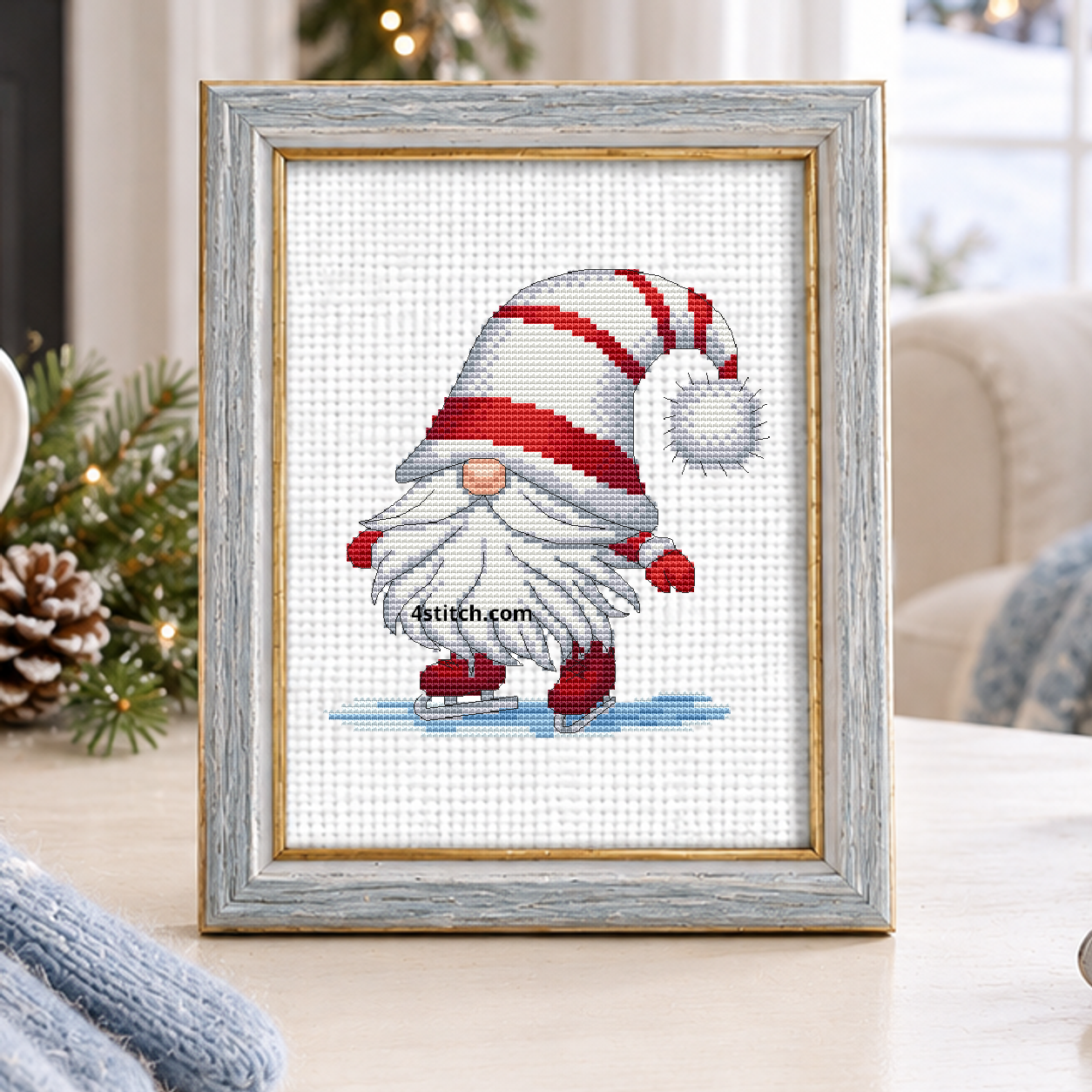 Ice Skating Christmas Gnome with a striped-hat gnome gliding in red ice skates across a snowy blue surface, on white Aida in a silver-blue frame in a light winter living room.