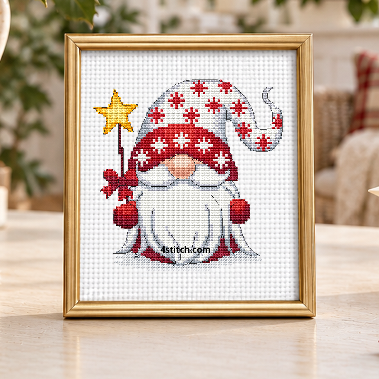 Christmas Star Gnome with a golden star on a ribboned wand and a red-and-white snowflake-patterned hat, on white Aida in a champagne-gold frame in a sunny star-themed holiday room.