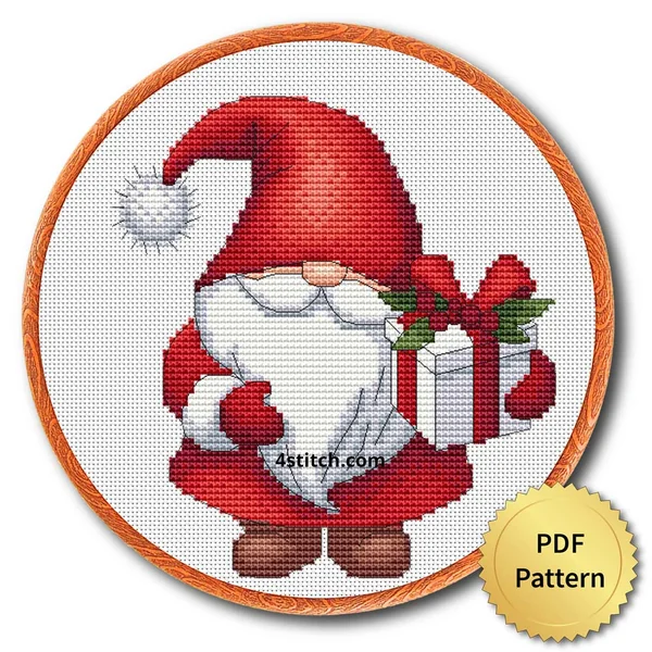 Holly Gift Santa Gnome cross stitch design in an embroidery hoop with a PDF Pattern medal