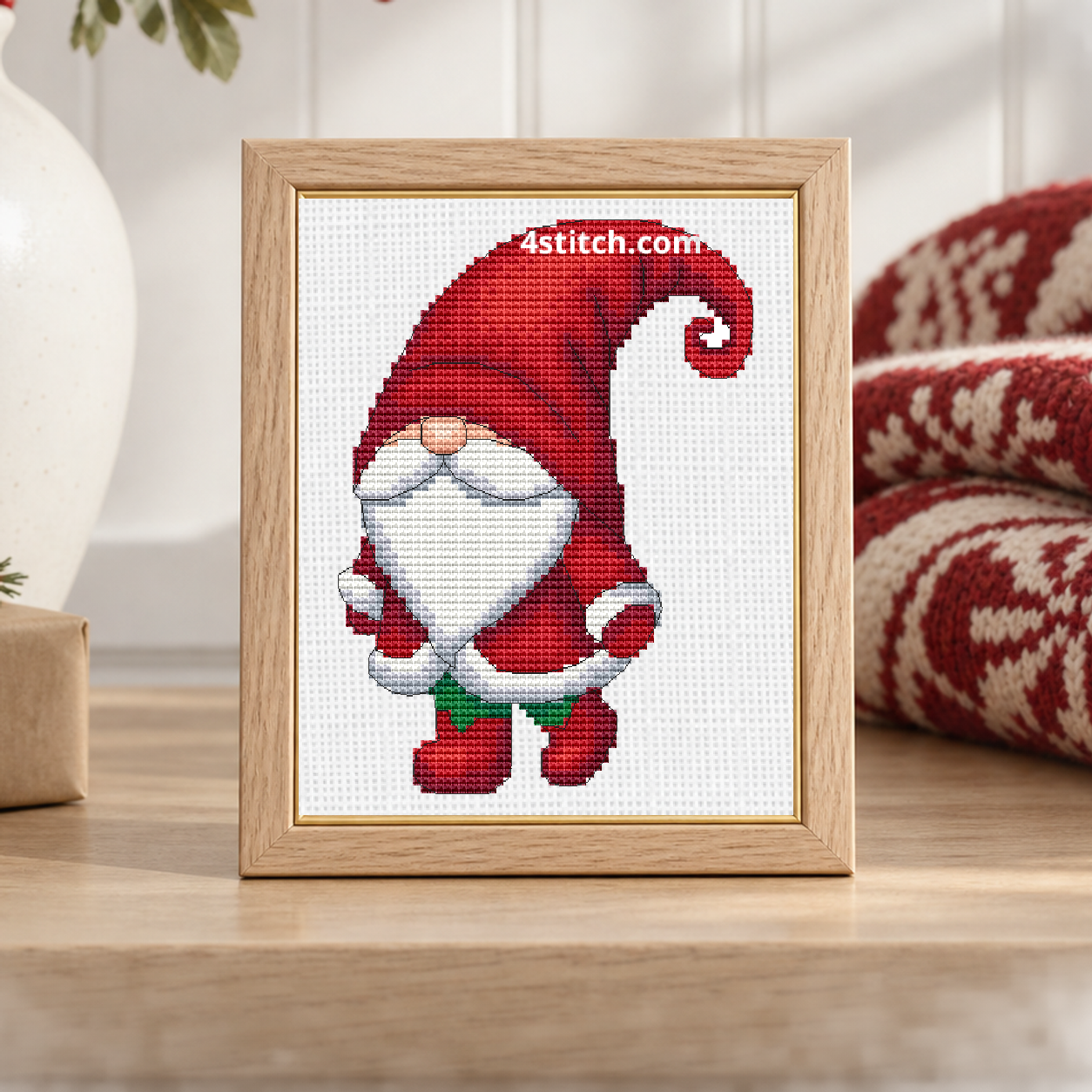 Close-up of Curled Hat Santa Gnome on white Aida in a pale oak frame on a light Scandinavian Christmas console.