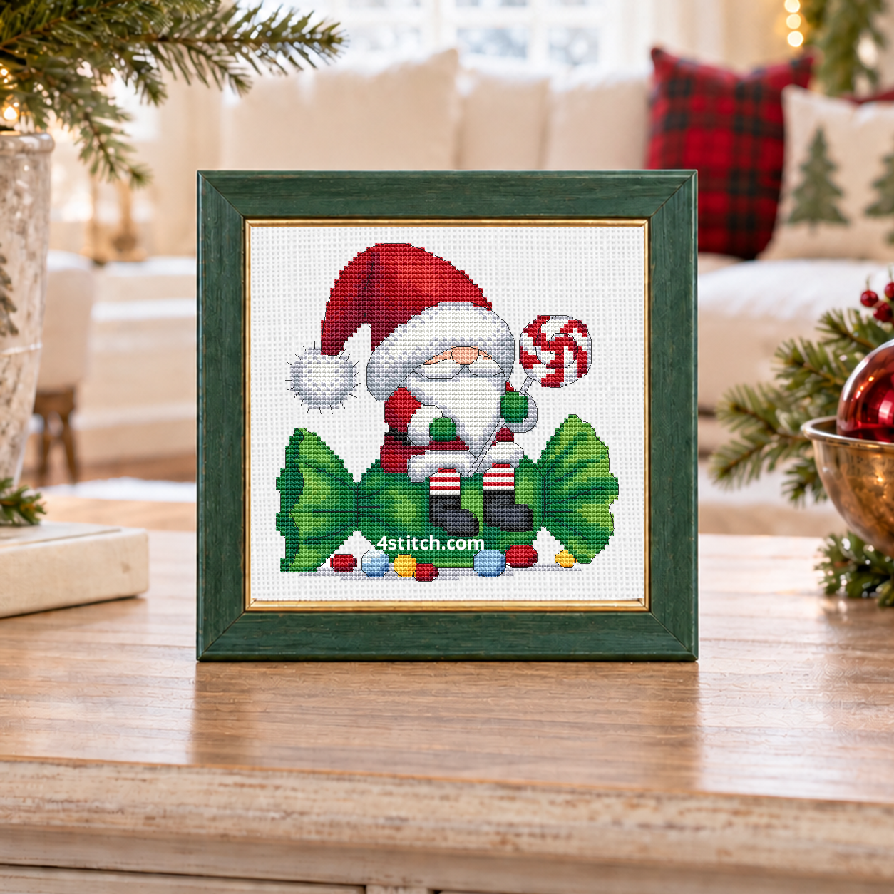 Close-up of Peppermint Tree Gnome on white Aida in a soft forest-green frame on an airy Christmas tree console.