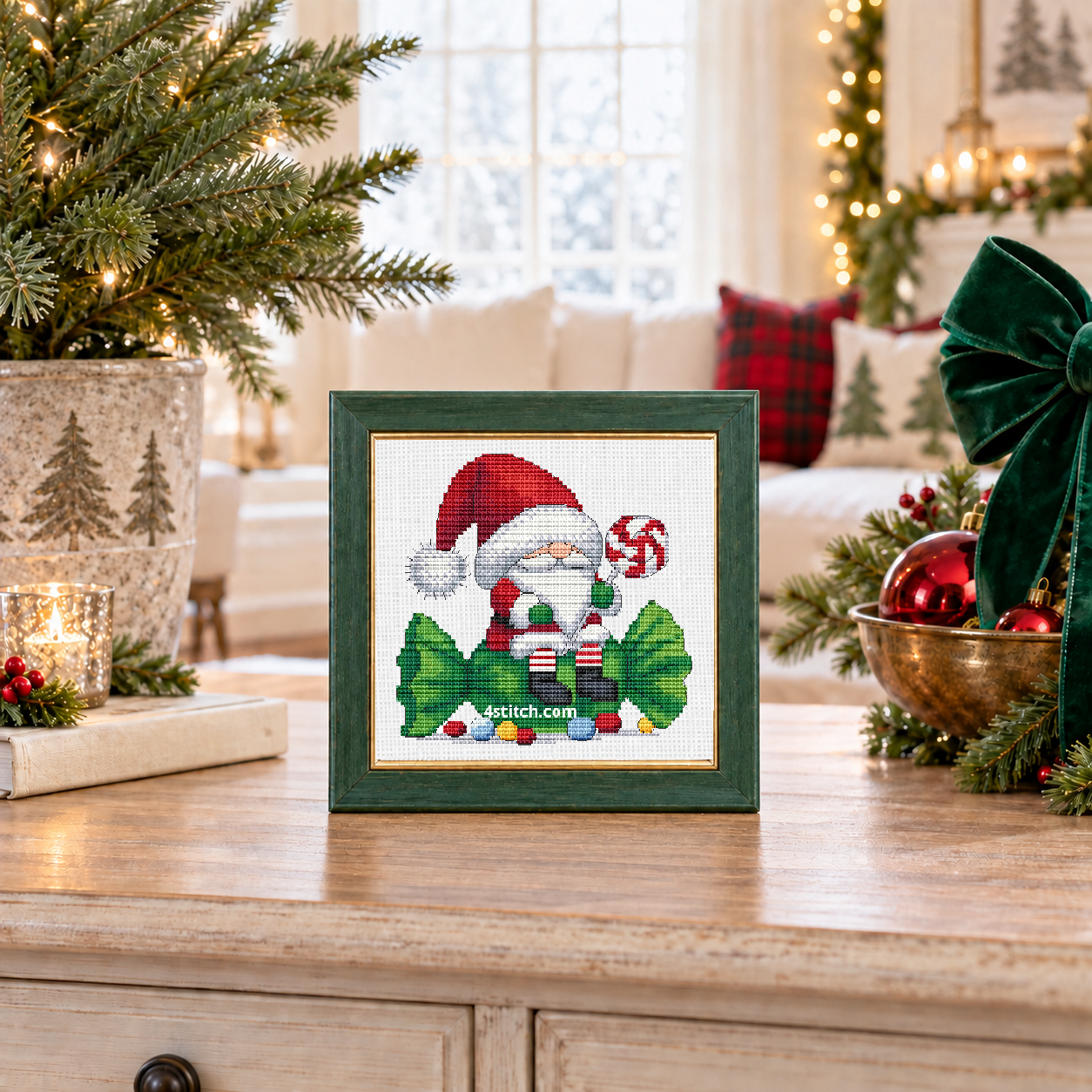 Wider interior view of Peppermint Tree Gnome on white Aida in a soft forest-green frame on an airy Christmas tree console, with the small frame resting among coordinating Christmas decorations.
