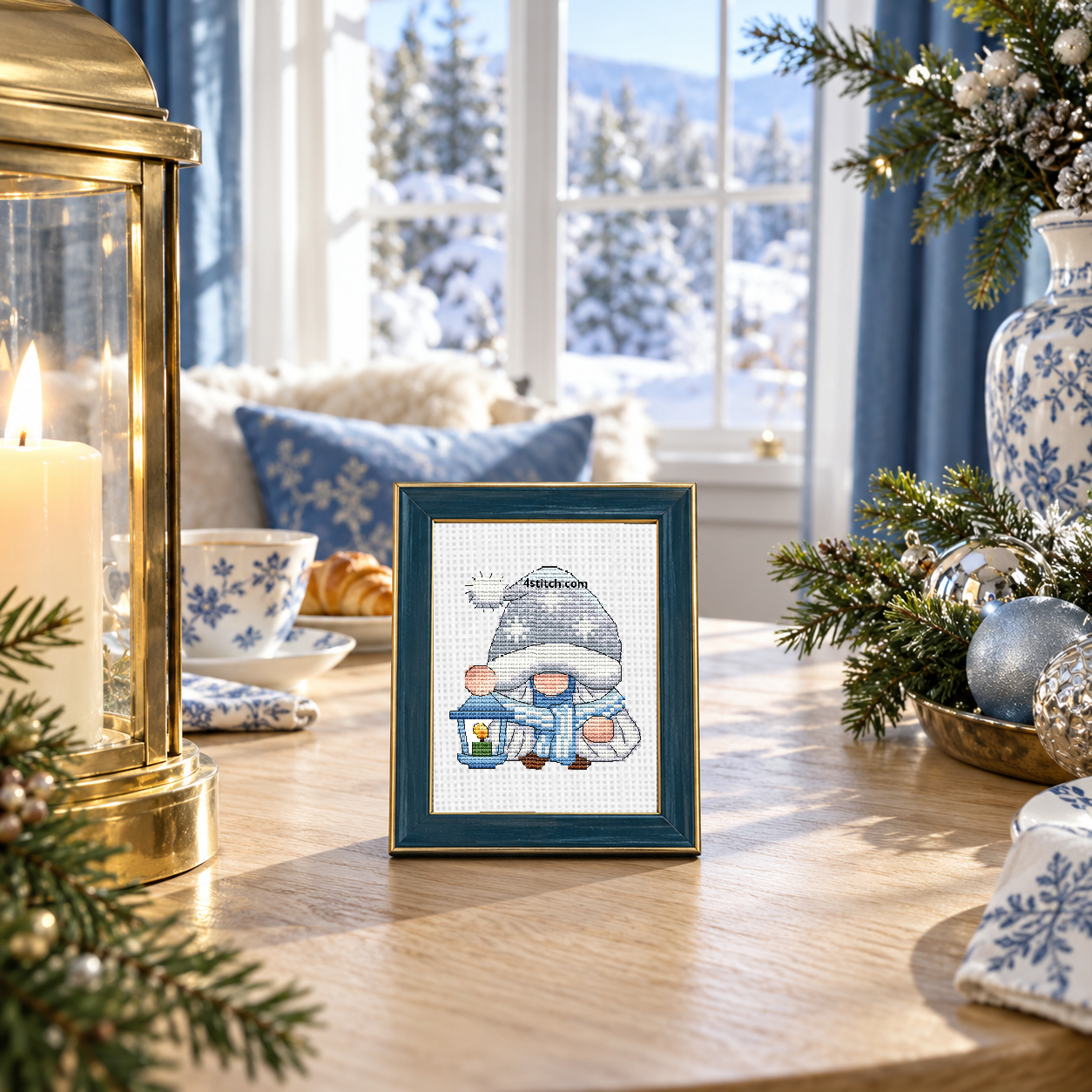 a snowflake-hat winter gnome holding a blue lantern on continuous white Aida in a small teal-and-gold frame in a bright cozy Christmas home.