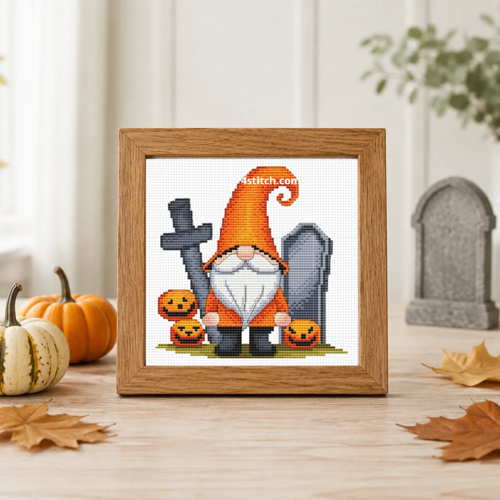 Framed Graveyard Pumpkin Gnome cross stitch on white Aida in a bright autumn farmhouse interior