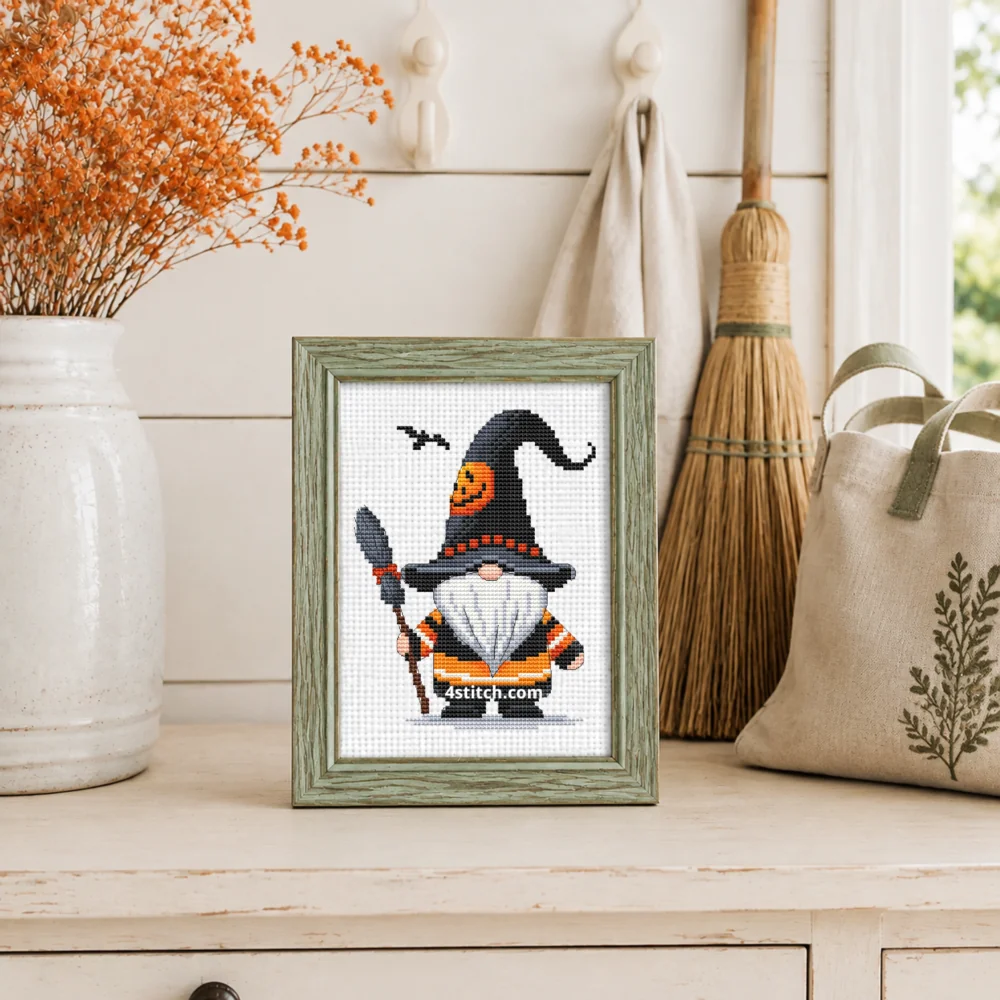 Small framed Black Hat Broom Witch Gnome stitched on white Aida in a bright themed interior; complete original motif and 4stitch.com watermark.