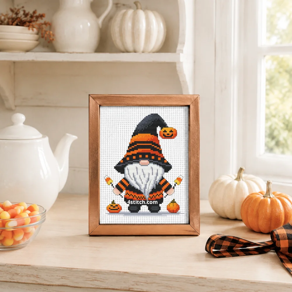 Small framed Black and Orange Witch Gnome stitched on white Aida in a bright themed interior; complete original motif and 4stitch.com watermark.
