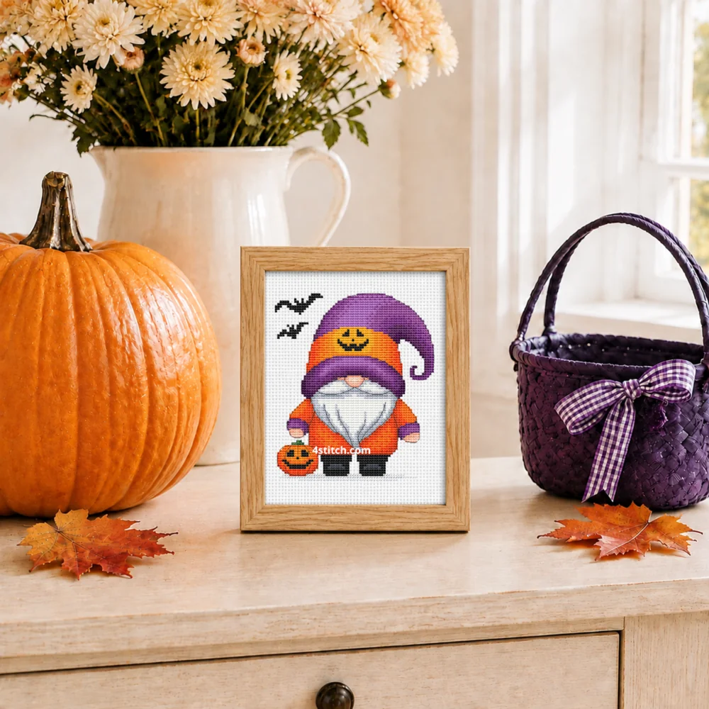 Small framed Pumpkin Hoodie Halloween Gnome on white Aida in a bright themed interior, with the complete original motif and its 4stitch.com watermark.