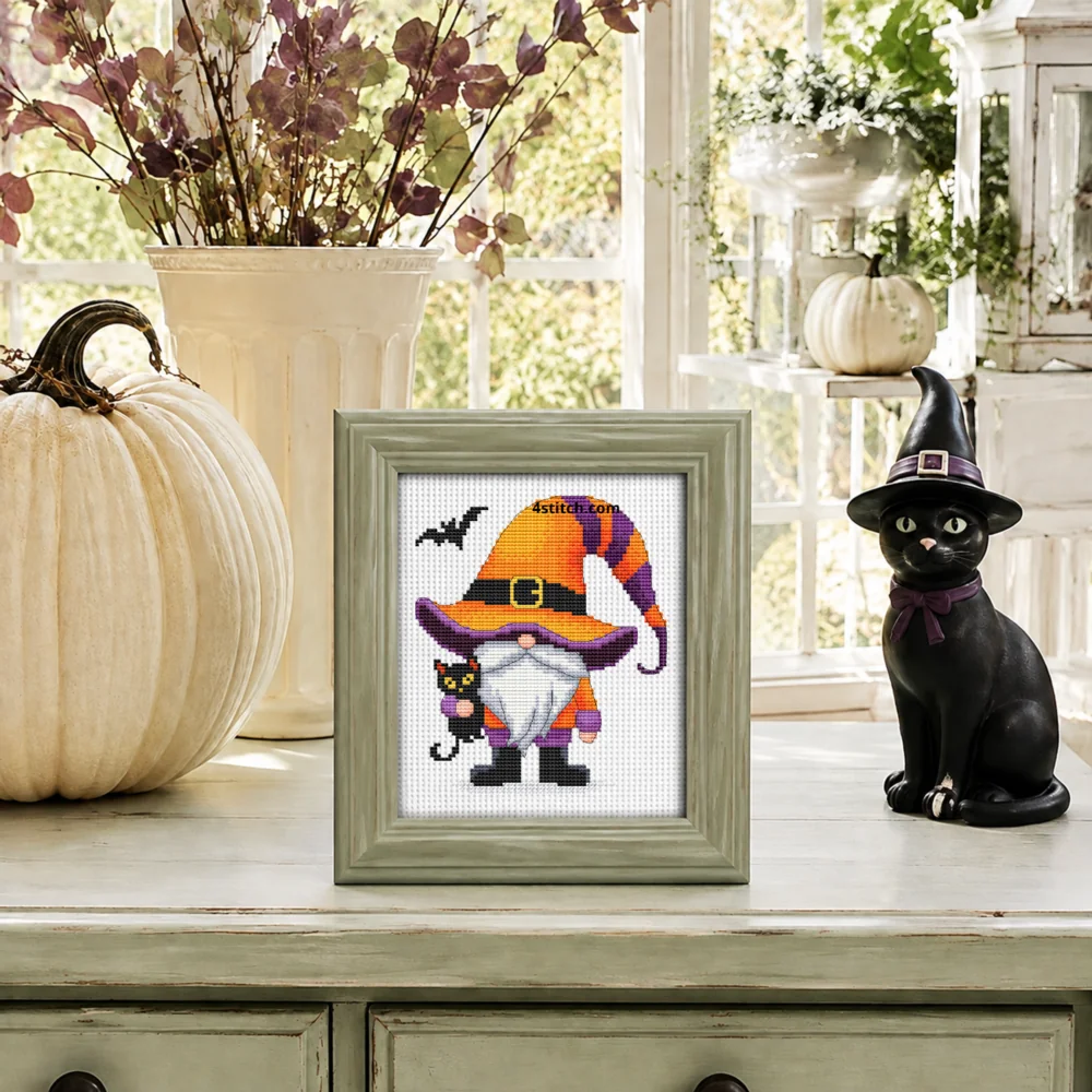 Small framed Black Cat Witch Gnome on white Aida in a bright themed interior, with the complete original motif and its 4stitch.com watermark.