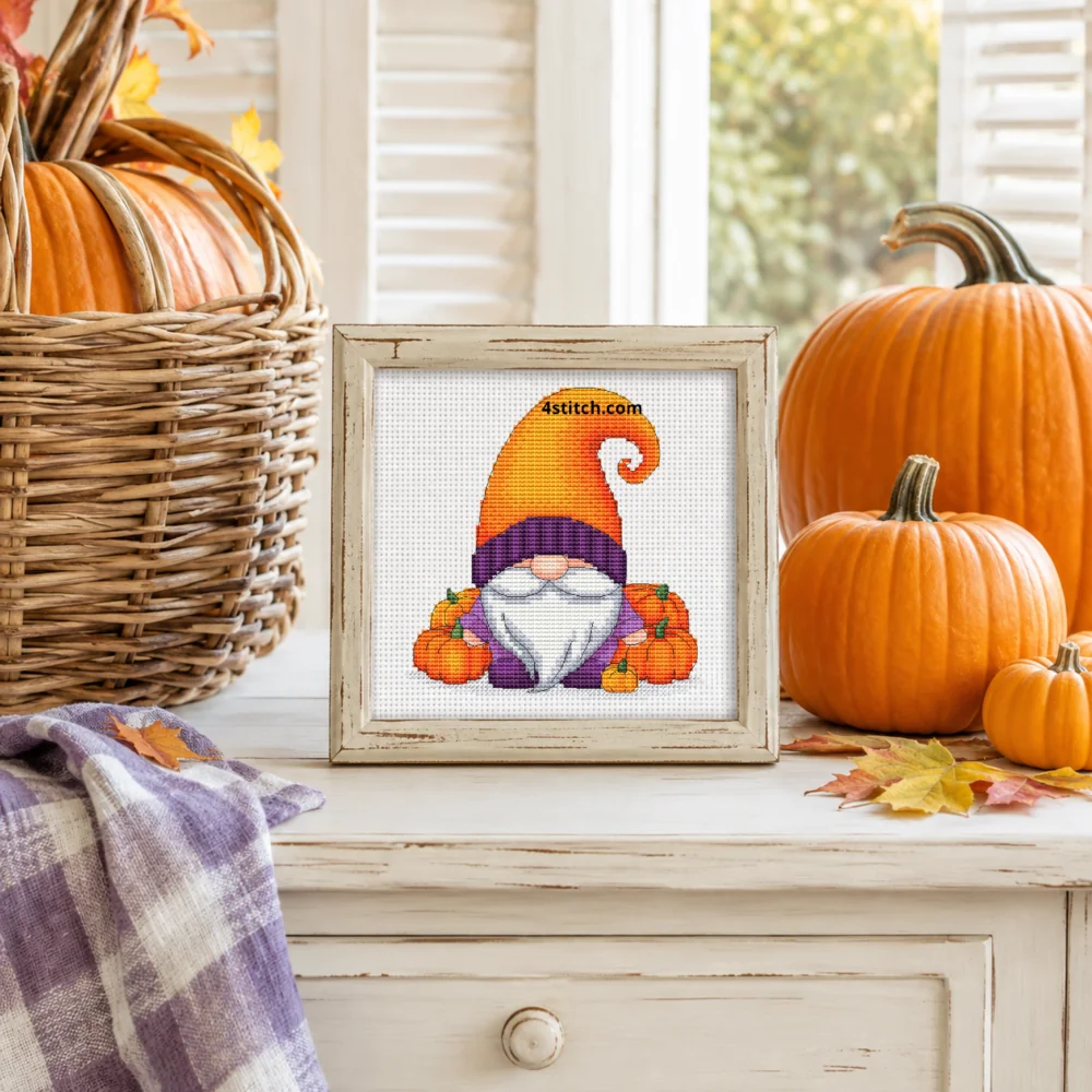 Small framed Pumpkin Patch Orange Hat Gnome on white Aida in a bright themed interior, with the complete original motif and its 4stitch.com watermark.