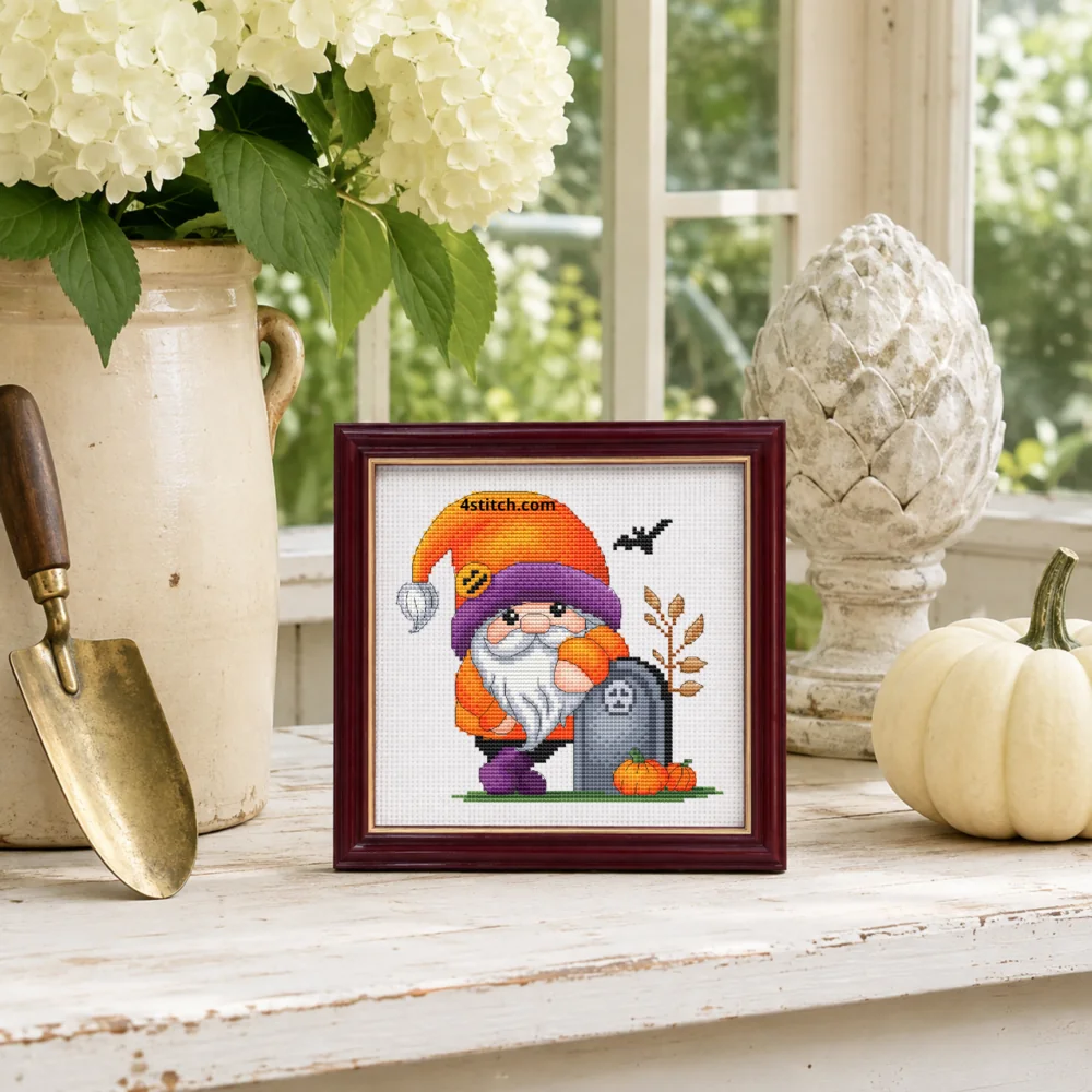Small framed Tombstone Hug Halloween Gnome on white Aida in a bright themed interior, with the complete original motif and its 4stitch.com watermark.