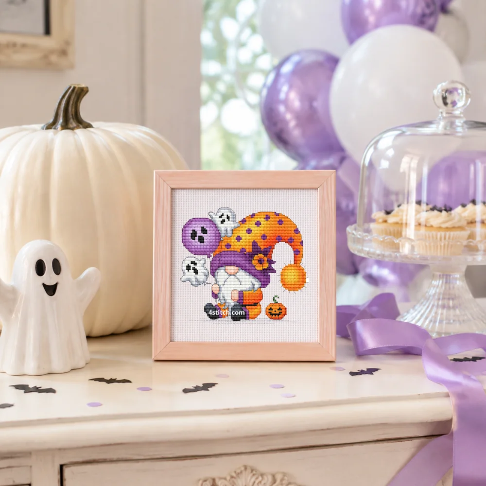Small framed Ghost Balloon Halloween Gnome on white Aida in a bright themed interior, with the complete original motif and its 4stitch.com watermark.