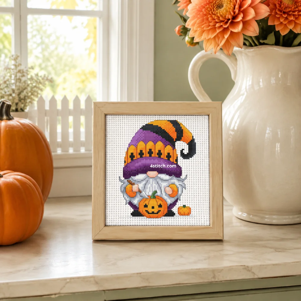 Small framed Jack-o'-Lantern Fence Hat Gnome on white Aida in a bright themed interior, with the complete original motif and its 4stitch.com watermark.