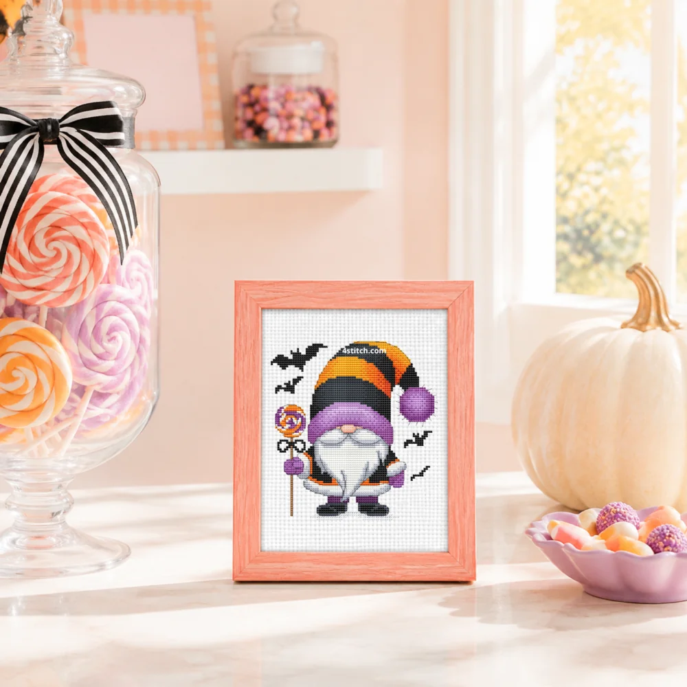 Small framed Lollipop Witch Halloween Gnome on white Aida in a bright themed interior, with the complete original motif and its 4stitch.com watermark.
