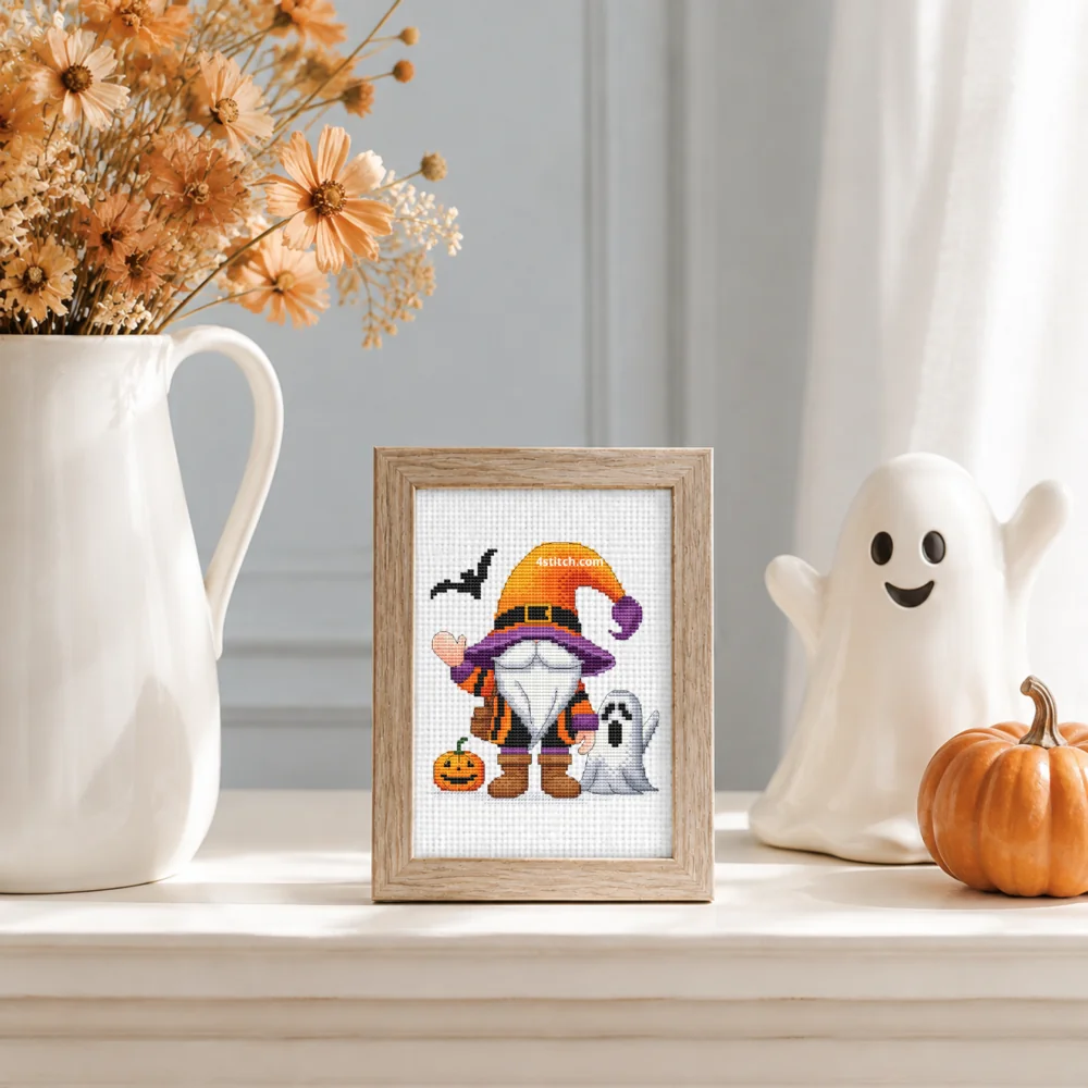 Small framed Witch and Ghost Halloween Gnome on white Aida in a bright themed interior, with the complete original motif and its 4stitch.com watermark.