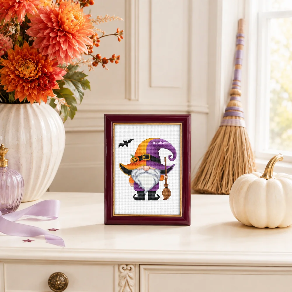 Small framed Purple Pumpkin-Hat Witch Gnome on white Aida in a bright themed interior, with the complete original motif and its 4stitch.com watermark.