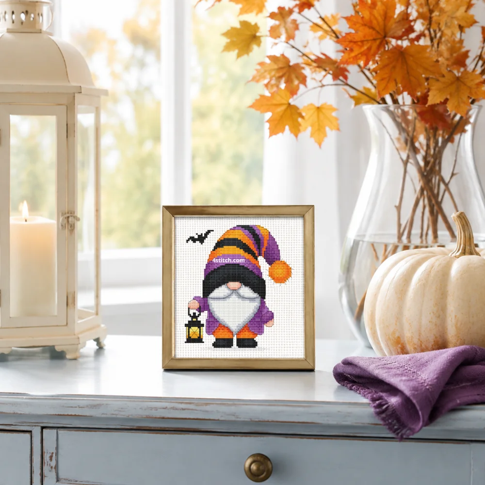 Small framed Lantern Striped-Hat Halloween Gnome on white Aida in a bright themed interior, with the complete original motif and its 4stitch.com watermark.
