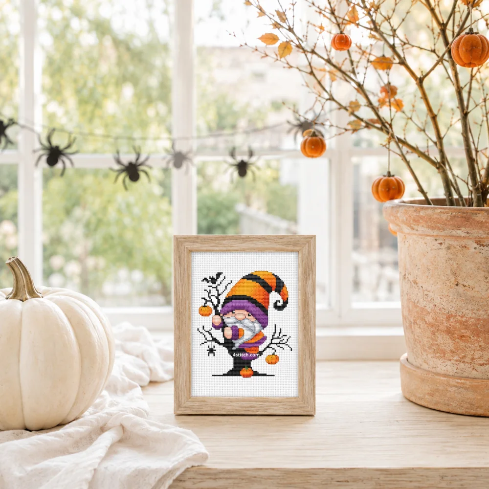Small framed Pumpkin Tree Halloween Gnome on white Aida in a bright themed interior, with the complete original motif and its 4stitch.com watermark.