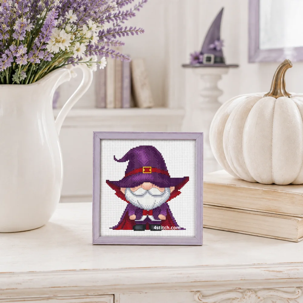 Purple Witch Gnome Cross Stitch Pattern shown as a small framed embroidery on white Aida in a bright Halloween interior.