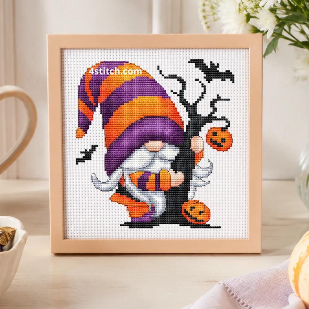 Candy and Pumpkin Halloween Gnome on white Aida in a small frame, photographed close up in a bright cozy autumn interior