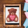 Bear with heart cross stitch pattern featuring a cute brown bear holding a heart