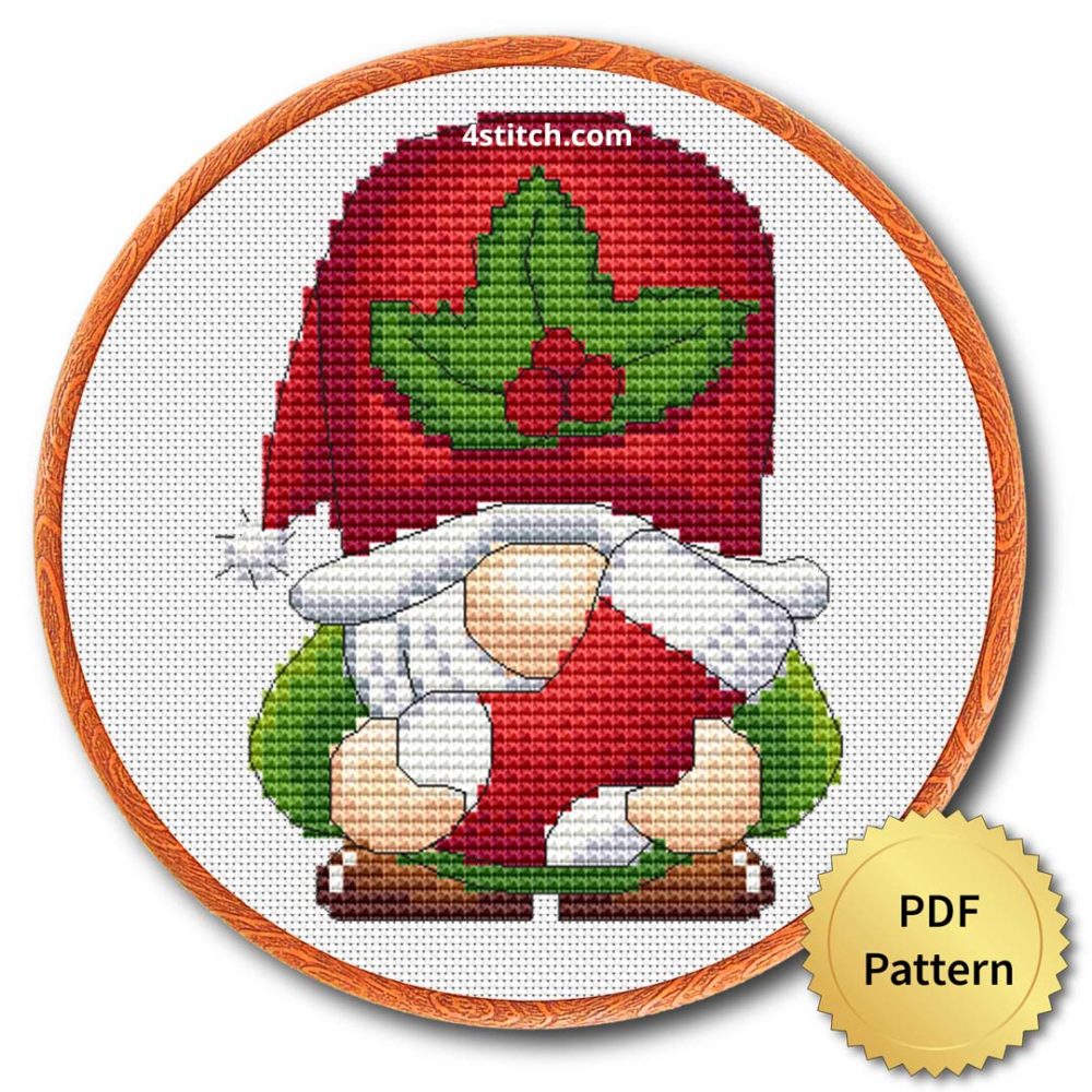 Holly Hat Christmas Gnome Cross Stitch Pattern shown in an embroidery hoop with a gold PDF Pattern medal