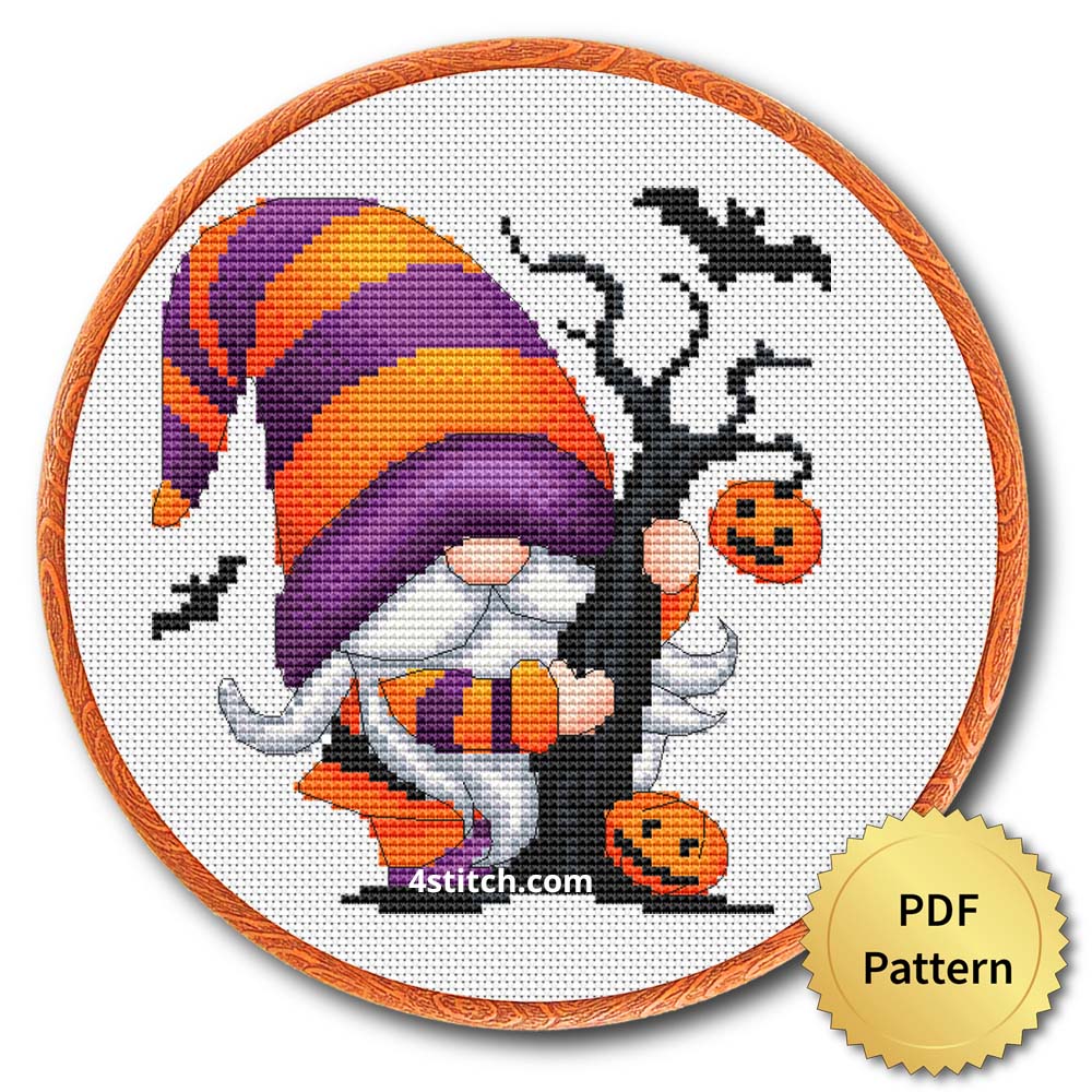 Candy and Pumpkin Halloween Gnome displayed on white Aida in a wooden embroidery hoop with a PDF pattern badge